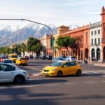 Calle concurrida con ciclistas y montañas al fondo.