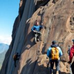 Escaladores subiendo una pared de roca al aire libre.