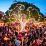 Festival nocturno en ciudad con árbol iluminado.
