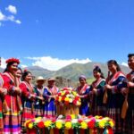Grupo en atuendos tradicionales en paisaje montañoso.