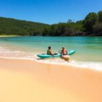Dos personas en kayak en playa tropical