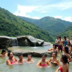 Personas disfrutando en un lago natural rodeado de montañas.